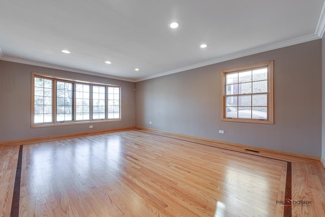 empty room featuring crown molding and light hardwood / wood-style floors