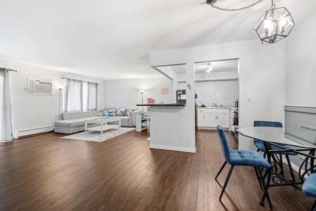 dining area featuring dark hardwood / wood-style flooring, a chandelier, a wall mounted air conditioner, and baseboard heating