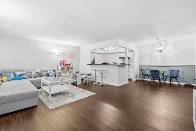 living room featuring an inviting chandelier and dark wood-type flooring