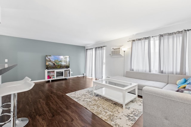 living room with dark hardwood / wood-style floors and a wall unit AC