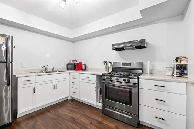 kitchen featuring dark wood-type flooring, sink, exhaust hood, appliances with stainless steel finishes, and white cabinets