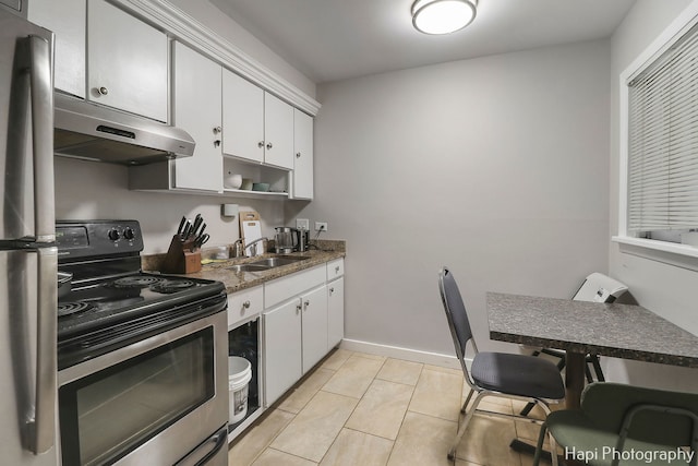 kitchen featuring light tile patterned flooring, white cabinetry, sink, dark stone counters, and stainless steel appliances