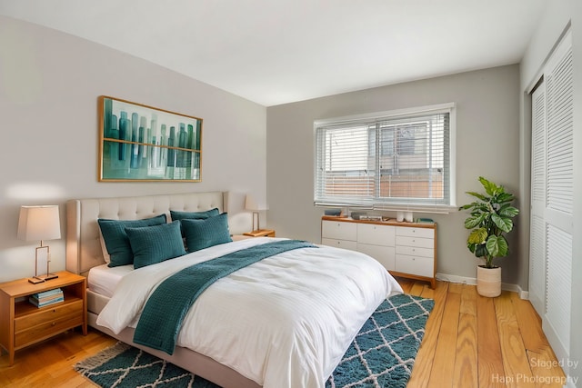 bedroom with light hardwood / wood-style floors and a closet