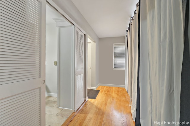 corridor with a barn door and light hardwood / wood-style flooring