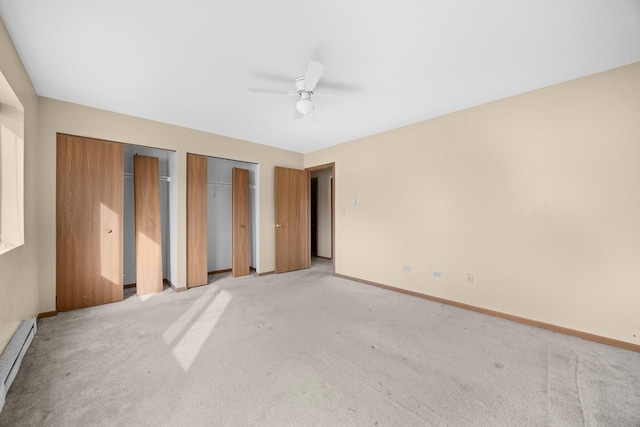 unfurnished bedroom with ceiling fan, light colored carpet, a baseboard radiator, and two closets