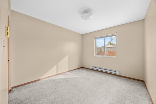 spare room with a baseboard heating unit and light carpet