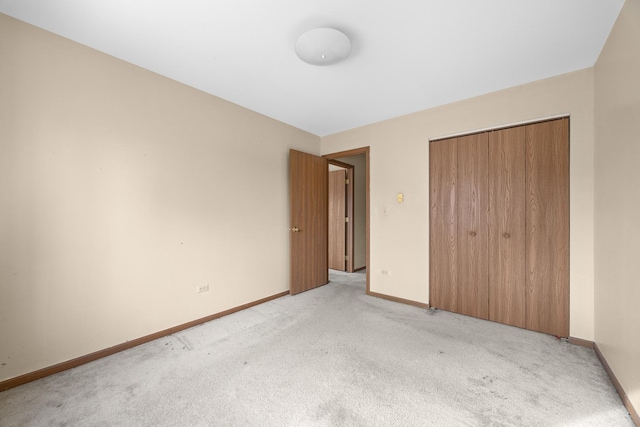 unfurnished bedroom featuring a closet and light colored carpet