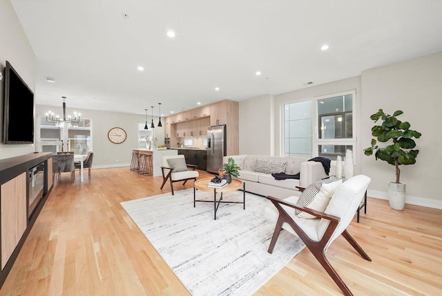 living room with light hardwood / wood-style floors and a chandelier