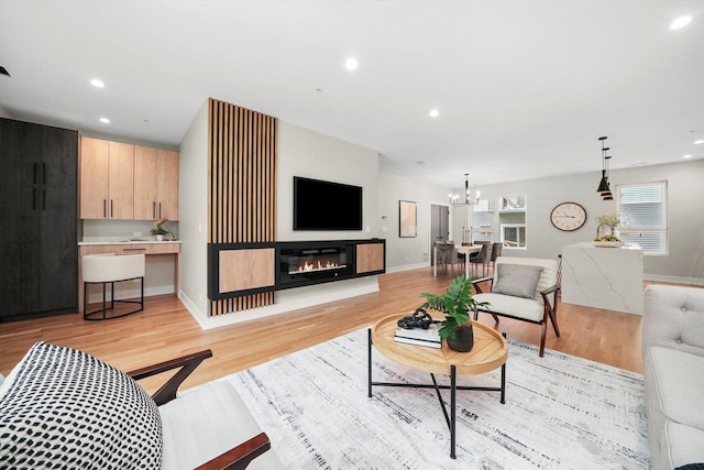 living room featuring light hardwood / wood-style floors and an inviting chandelier