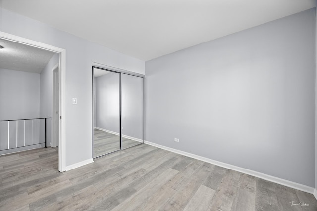 unfurnished bedroom with light hardwood / wood-style floors and a closet