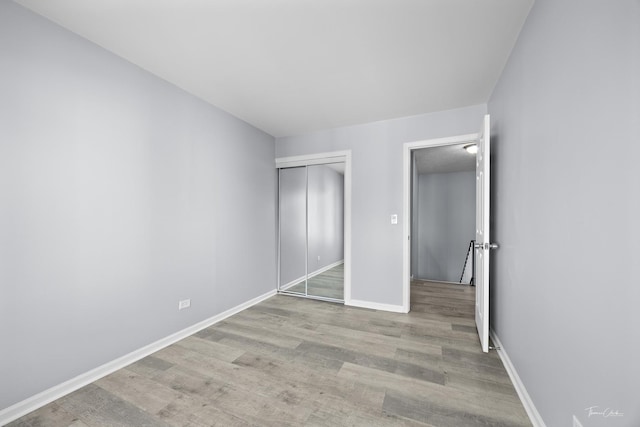 unfurnished bedroom with light hardwood / wood-style floors and a closet