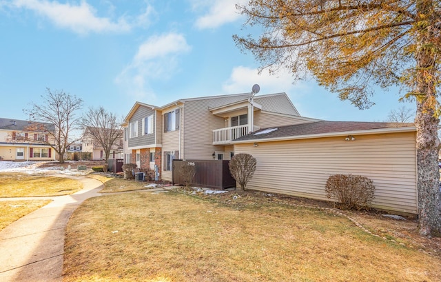 view of home's exterior featuring central AC unit, a yard, and a balcony