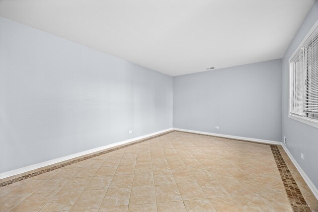 tiled spare room with ceiling fan