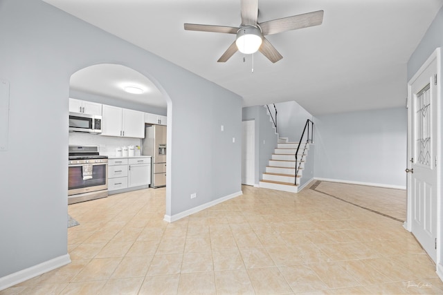 unfurnished living room featuring light tile patterned floors and ceiling fan