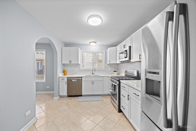 kitchen with backsplash, stainless steel appliances, and white cabinets