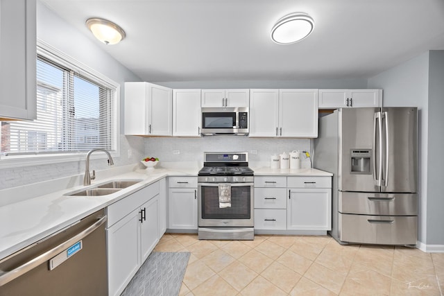 kitchen with appliances with stainless steel finishes, sink, and white cabinets