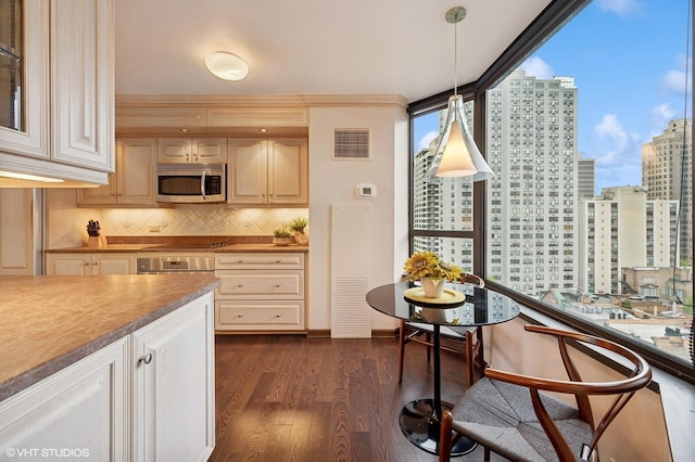 kitchen featuring hanging light fixtures, decorative backsplash, plenty of natural light, and dark wood-type flooring