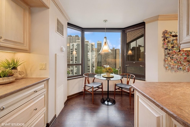 dining area featuring ornamental molding and dark wood-type flooring