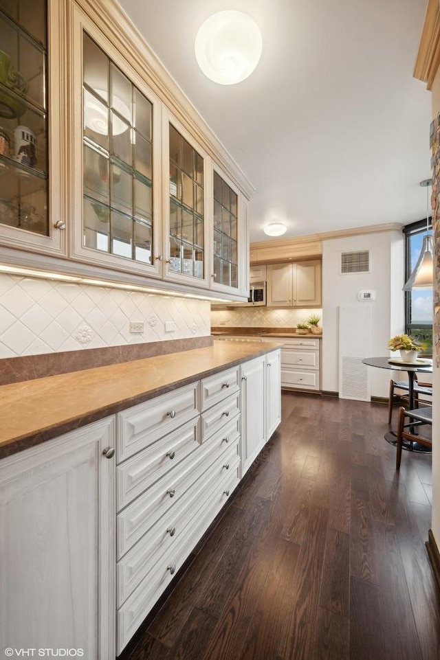 kitchen with backsplash, dark hardwood / wood-style flooring, and ornamental molding