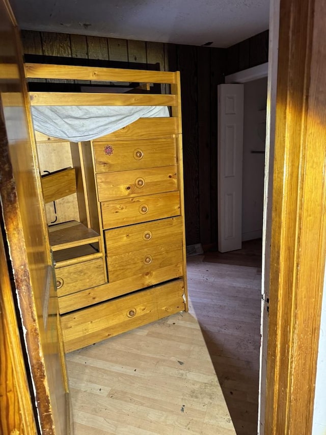 unfurnished bedroom with wood-type flooring and wood walls