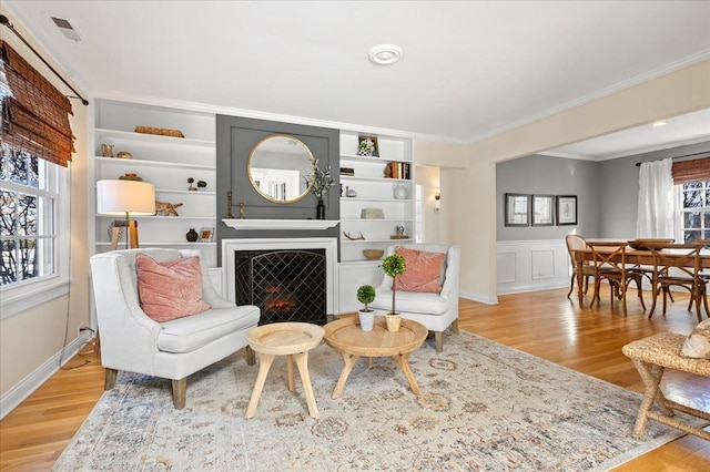 living room featuring crown molding and light hardwood / wood-style floors