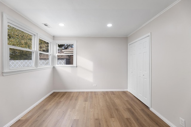 unfurnished bedroom featuring wood-type flooring, a closet, and crown molding