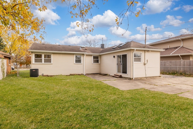 back of property with a lawn, a patio, and central AC