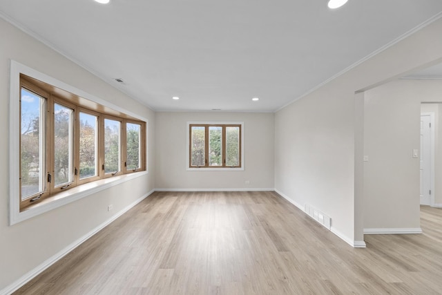 empty room featuring crown molding and light hardwood / wood-style floors