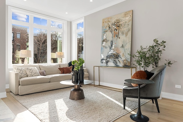 sitting room featuring ornamental molding and light hardwood / wood-style floors