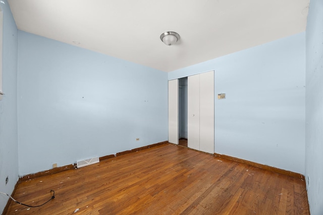 unfurnished bedroom featuring hardwood / wood-style floors and a closet