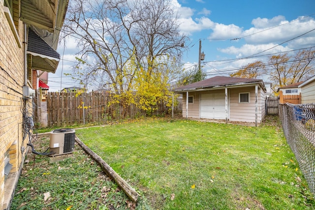 view of yard with a garage, an outbuilding, and central air condition unit