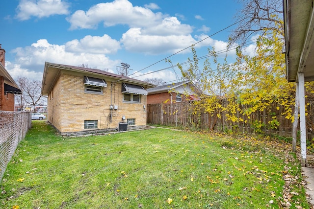 back of house with cooling unit and a lawn