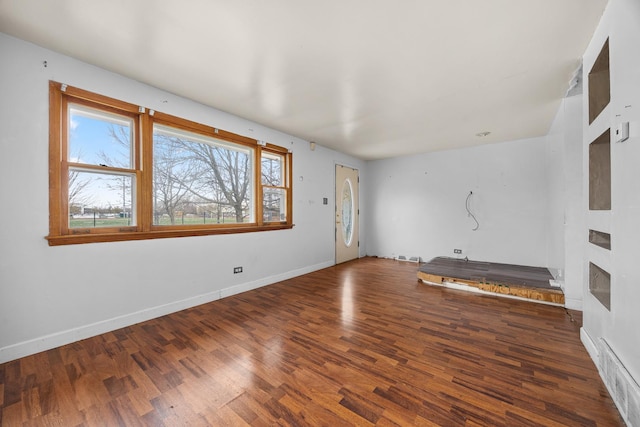 unfurnished living room with dark wood-type flooring