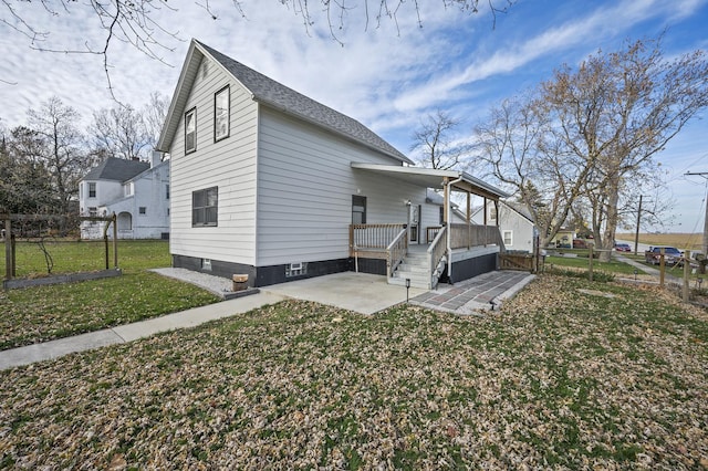 view of side of property with a porch, a patio, and a yard