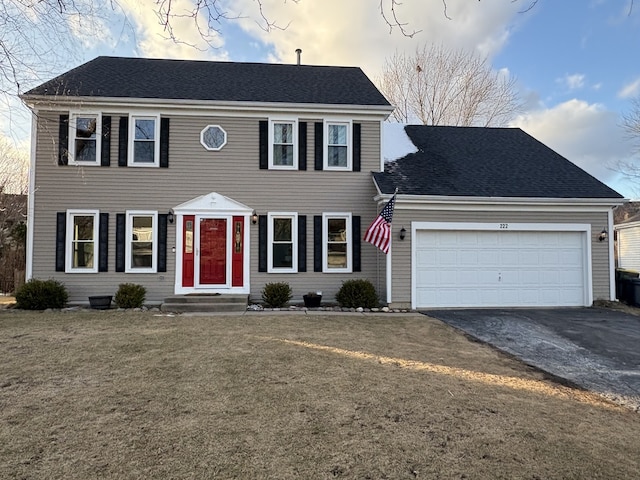 colonial-style house with a garage and a yard