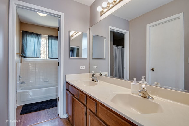 bathroom featuring vanity, hardwood / wood-style floors, and a bath