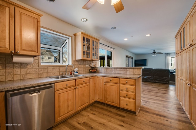 kitchen with sink, decorative backsplash, stainless steel dishwasher, kitchen peninsula, and light wood-type flooring