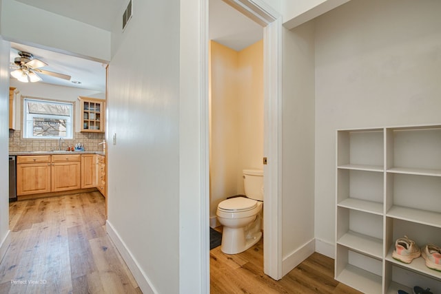 bathroom featuring decorative backsplash, hardwood / wood-style flooring, vanity, ceiling fan, and toilet