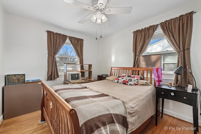 bedroom featuring multiple windows, ceiling fan, and light hardwood / wood-style flooring