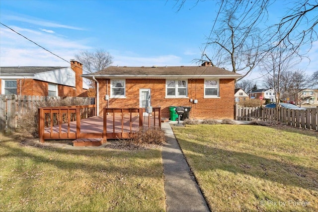 back of house featuring a wooden deck and a lawn