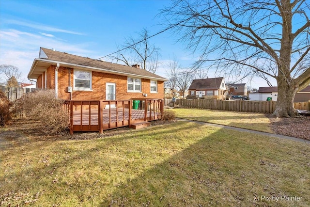 rear view of property with a deck and a lawn