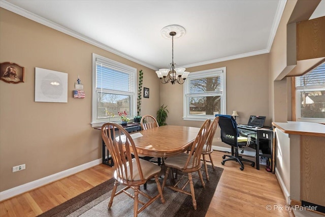 dining area with ornamental molding, a wealth of natural light, a notable chandelier, and light hardwood / wood-style flooring