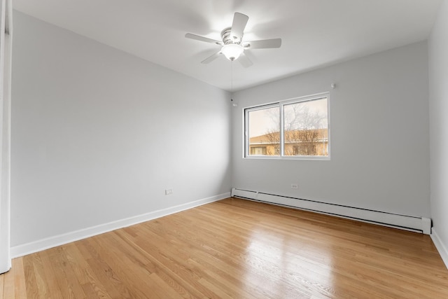 spare room featuring a baseboard radiator, ceiling fan, and light hardwood / wood-style flooring