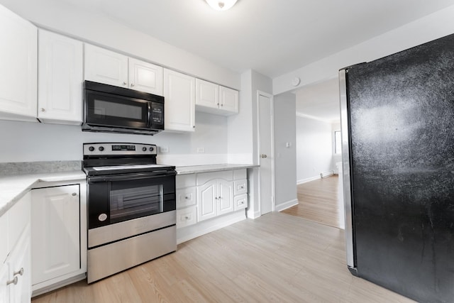 kitchen with white cabinetry, appliances with stainless steel finishes, and light hardwood / wood-style flooring