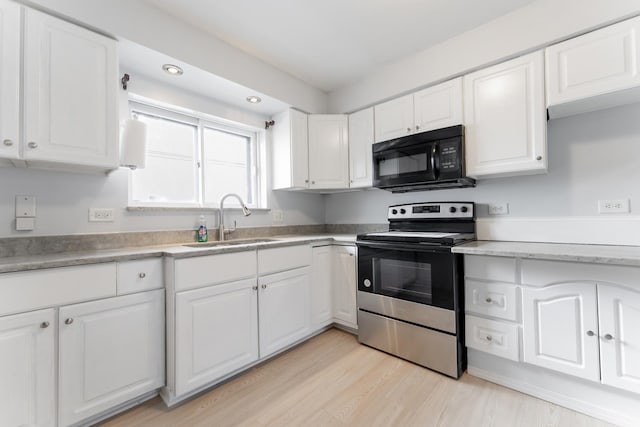 kitchen with sink, stainless steel electric range, light hardwood / wood-style floors, and white cabinets