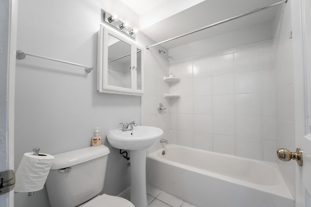 bathroom with tile patterned floors, toilet, and tiled shower / bath combo