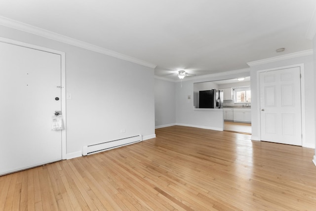 unfurnished living room featuring a baseboard heating unit, crown molding, sink, and light wood-type flooring