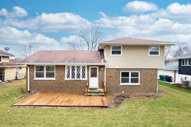 rear view of property featuring a wooden deck, a yard, and central air condition unit