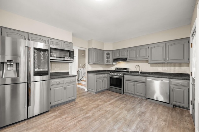 kitchen featuring sink, light hardwood / wood-style floors, gray cabinetry, and stainless steel appliances