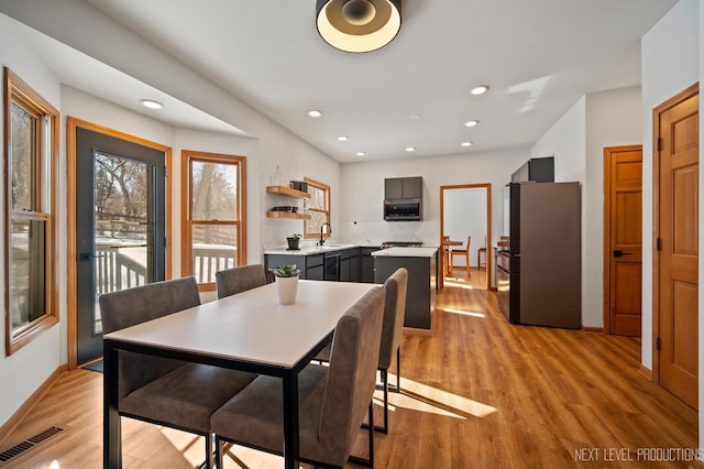 dining room featuring sink and light hardwood / wood-style floors